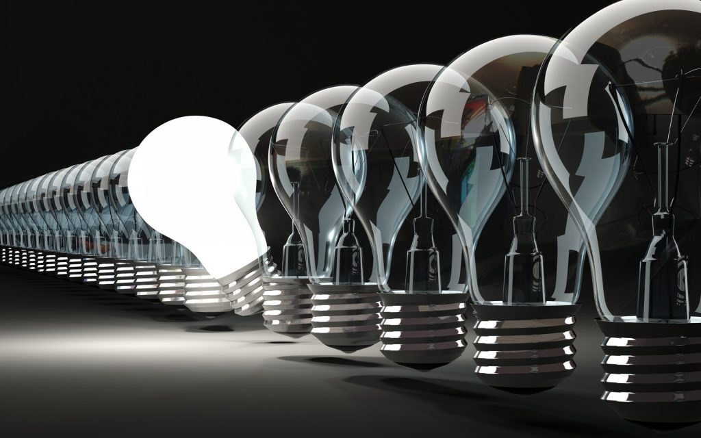 illustration - lightbulbs in a row, with one glowing and titling out of line