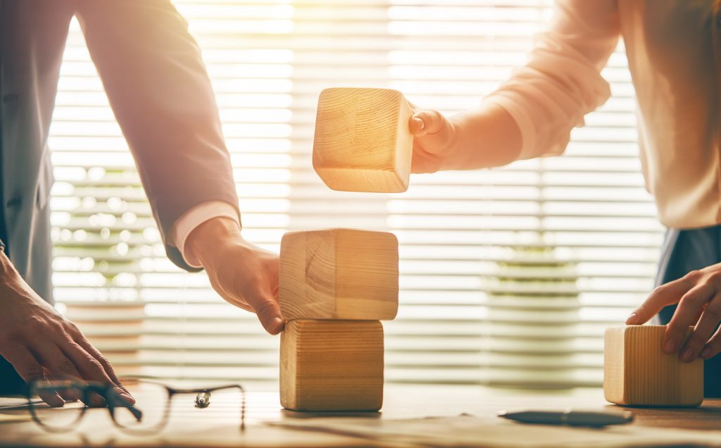 Office workers stacking building blocks