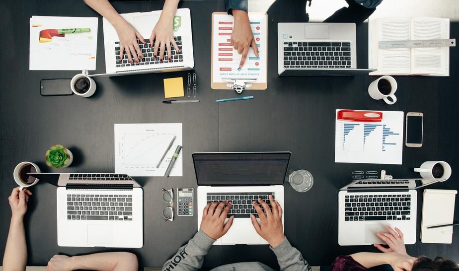 Overhead view of laptops hands and notes