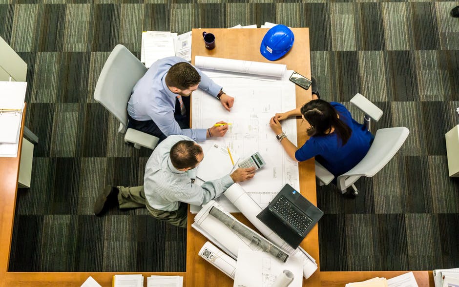 Overhead view of three people going over workflows