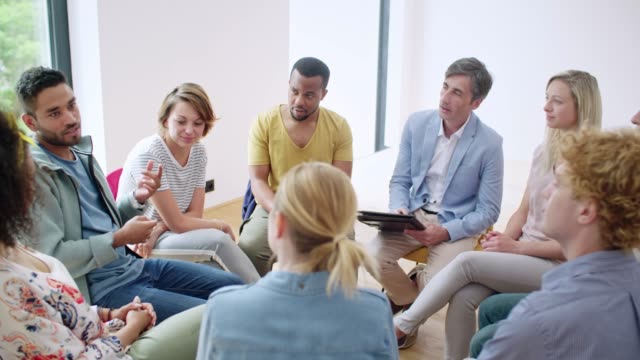 Man talking in circle of people. 