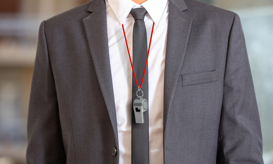 Person in suit with a whistle on a cord around neck