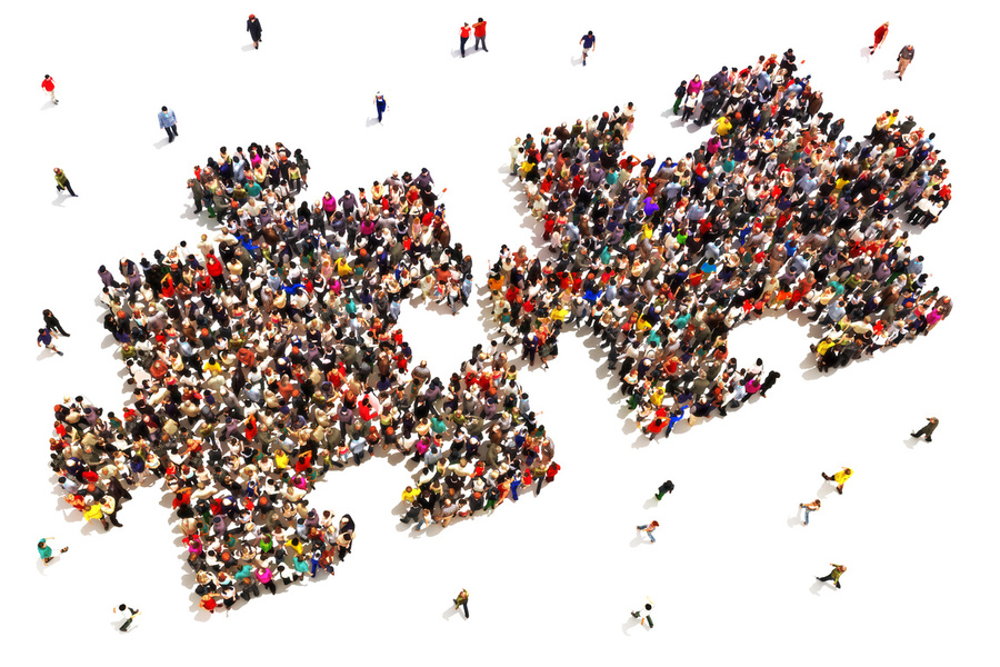 Overhead image of lots of people, standing in the shape of two puzzle pieces