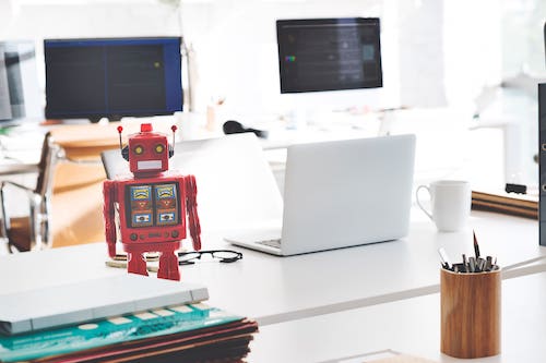 Mini robot on a desk with a computer